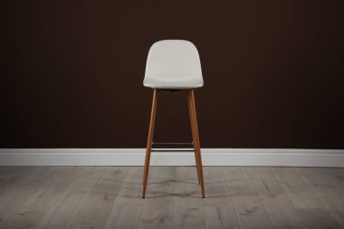 Kahverengi duvarın yanında şık bar taburesi