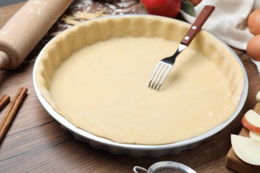 Çiğ hamur, çatal ve ahşap masa malzemeleri. Elmalı turta yapıyorum.