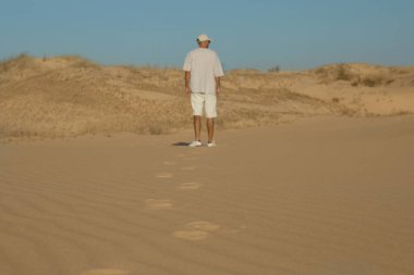 Çölde bir adam güneşli bir günde, arka planda