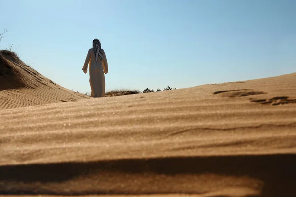 Homem Roupas Árabes Caminhando Pelo Deserto Dia Ensolarado Vista Traseira — Fotografia de Stock