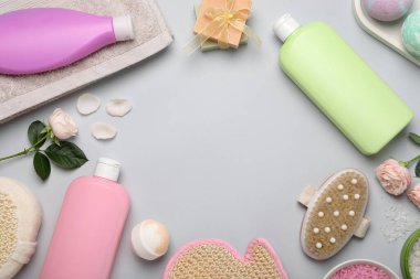 Açık gri zemin üzerinde duş jeli şişeleri ve güller ile düz kompozisyon, metin için boşluk