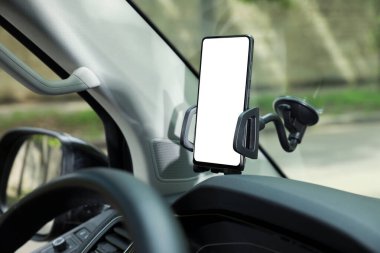 Otomobilin ön camında modern cep telefonu olan bir araba tutucusu. Tasarım için model