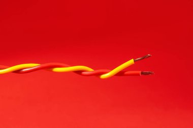 Kırmızı arka planda iki farklı elektrik kablosu.
