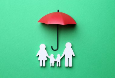 Mini şemsiye ve aile figürü yeşil arka planda, düz yatıyordu