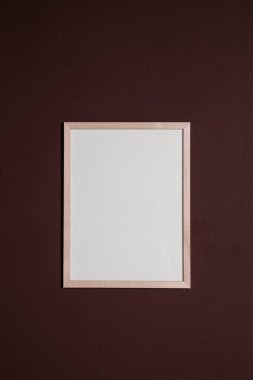 Kahverengi duvarda boş bir çerçeve. Tasarım için model