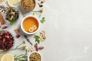 Taze demlenmiş çay ve kuru yapraklarla bezenmiş düz bir kompozisyon.