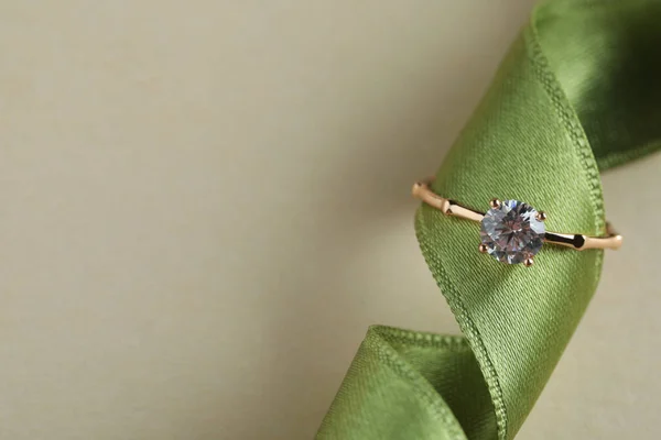 Yeşil Kurdeleli Güzel Bir Nişan Yüzüğü Bej Arka Planda Üst — Stok fotoğraf