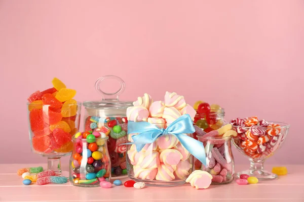 Üvegek Különböző Ízletes Cukorkák Rózsaszín Asztalon — Stock Fotó