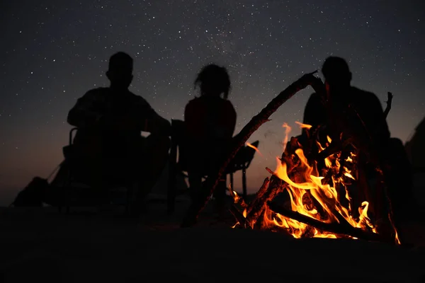 友人のグループは たき火の周りの夜に集まり 炎に焦点を当てる キャンプシーズン — ストック写真