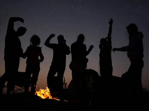 一群朋友在晚上篝火边举行聚会 野营季节 — 图库照片