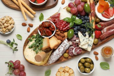 Beyaz ahşap masada servis edilen farklı lezzetli aperatifler.