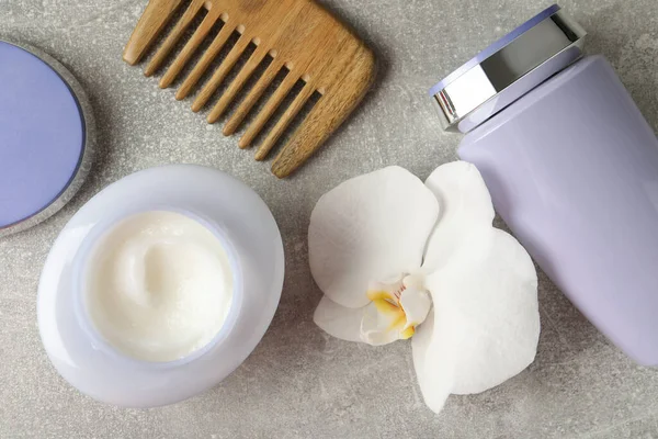 Saç Bakımı Kozmetik Ürünleri Orkide Çiçeği Gri Masa Üzerinde Tarak — Stok fotoğraf