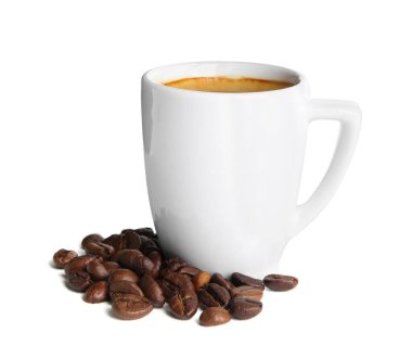 Bir fincan lezzetli espresso ve beyaz arka planda dağınık kahve çekirdekleri.