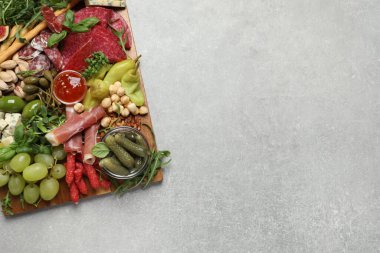 Açık gri masada servis edilen farklı lezzetli aperatifler, üst manzara. Metin için boşluk