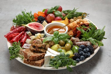 Açık gri masada servis edilen farklı lezzetli aperatifler.