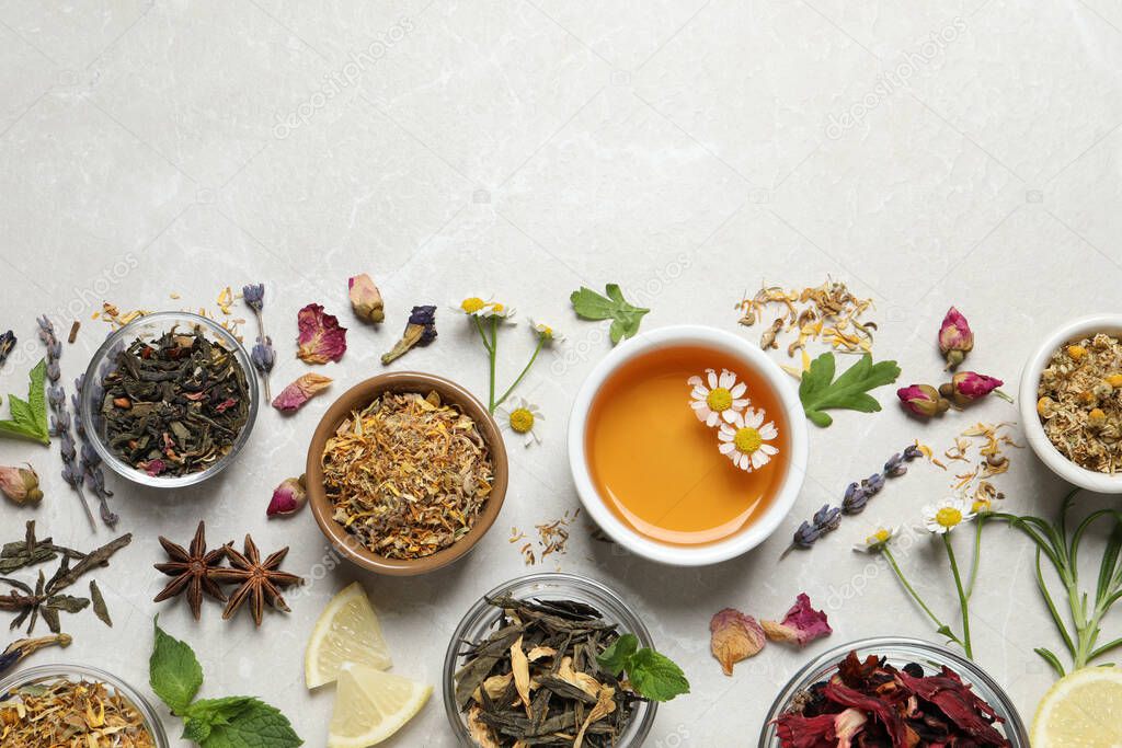 Flat lay composition with fresh brewed tea and dry leaves on light table, space for text