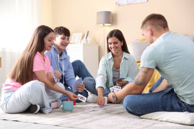 Bir grup arkadaş içeride iskambil oynuyor.