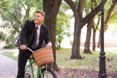 Şehir caddesinde bisiklet süren takım elbiseli bir adam. Metin için boşluk