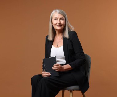 Kahverengi arka planda dizüstü bilgisayarı olan profesyonel psikoterapist.