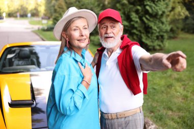 Modern Cabriolet yakınlarında şık bir çift açık havaya bakıyor.