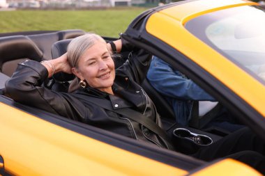 Şık bir son sınıf çifti. Cabriolet sürüşünden zevk alıyor. Seçici bir odak noktası.