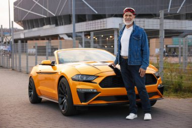 Modern Cabriolet yakınlarında şık bir kıdemli adam.