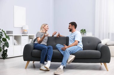 Mutlu çift evdeki kanepede birlikte vakit geçiriyor.