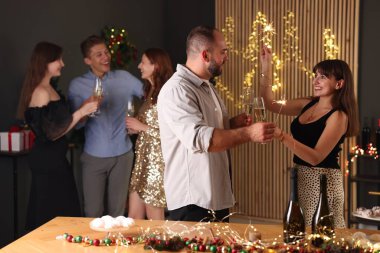 Arkadaşlar yılbaşını maytap ve şarap kadehleriyle kutluyorlar.