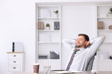 Ofiste klimalı bir adam oturuyor.