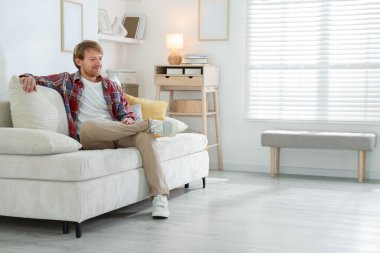 Evdeki kanepede oturan adam, mesaj için yer var.