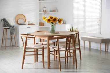 Beautiful sunflowers in vase on dining table at home