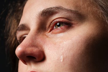 Üzgün kadın siyah arka planda ağlıyor, yakın plan