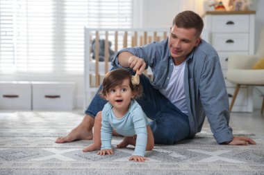 Baba evde bebeğinin saçını tarıyor, mesaj atmak için yer açıyor.