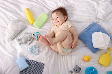 Güzel bebek ve yatağın üstünde farklı aksesuarlar.