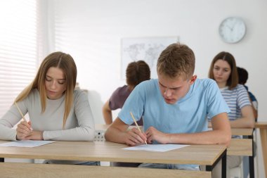 Ahşap masada sınava giren öğrenciler