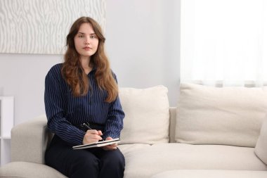 Profesyonel psikoterapist ofisteki kanepeye notlar alıyor, mesaj için yer açıyor.