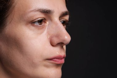 Üzgün kadın siyah arka planda ağlıyor, yakın plan. Metin için boşluk