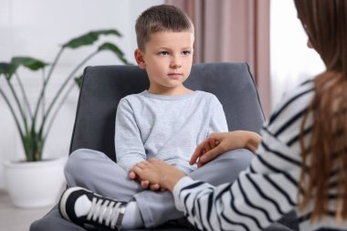 Anne üzgün oğlunu evde destekliyor, yakın plan.