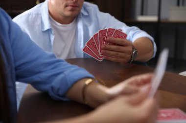 Ahşap masada kağıt oynayan arkadaşlar, yakın plan.