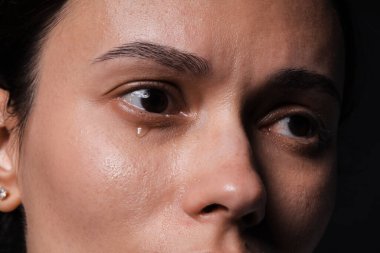 Üzgün kadın siyah arka planda ağlıyor, yakın plan