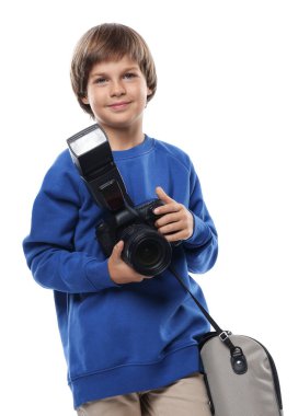 Meslek seçimi. Kameralı ve çantalı küçük çocuk beyaz arka planda fotoğrafçı gibi davranıyor.