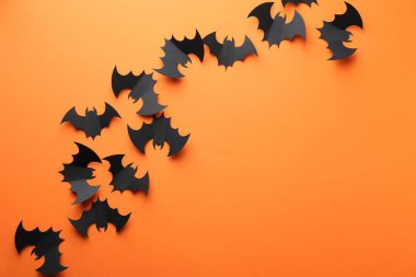 Cadılar Bayramı dekoru. Siyah kağıt yarasalar turuncu arka planda, düz yerde. Metin için boşluk