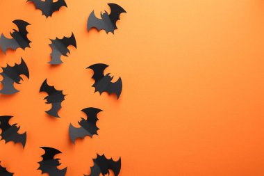 Cadılar Bayramı dekoru. Siyah kağıt yarasalar turuncu arka planda, düz yerde. Metin için boşluk