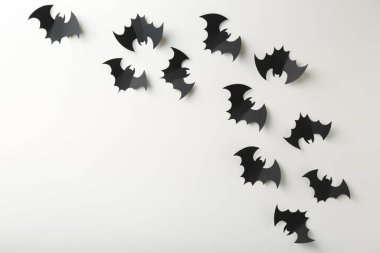 Cadılar Bayramı dekoru. Siyah kağıt yarasalar beyaz arka planda, düz yerde. Metin için boşluk