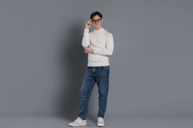 Gri arka planda şık kotlu adam.