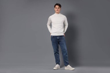 Gri arka planda şık kotlu adam.