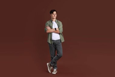 Kahverengi arka planda şık kotlu adam.