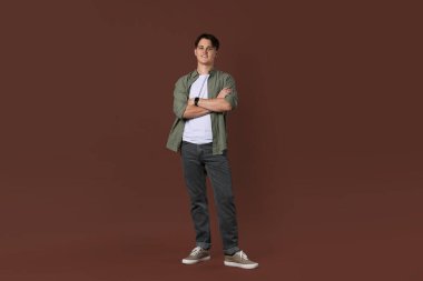 Kahverengi arka planda şık kotlu adam.