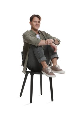 Beyaz arka planda sandalyede şık kotlu bir adam.