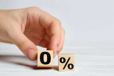 Komisyon yok. Bir kadının 0 ile küpü yan yana koyduğu tabela, yakın plan.